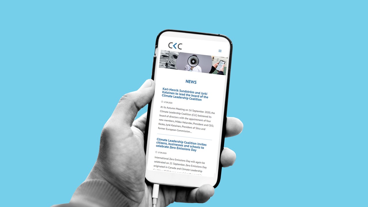 Hand holding a mobile phone, reading the news